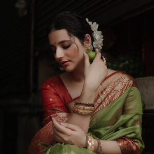 Stylish woman in a vibrant saree with gold jewelry, embracing her culture.