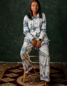 Elegant portrait of a young woman in comfortable printed pajamas, sitting indoors.