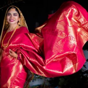 Smiling Indian woman in traditional red saree, showcasing Indian culture and fashion.