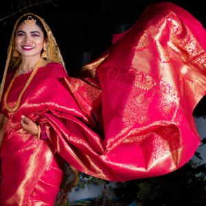 Smiling Indian woman in traditional red saree, showcasing Indian culture and fashion.